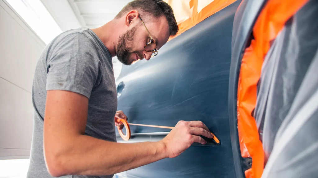 Covek koji reparira krilo automobila